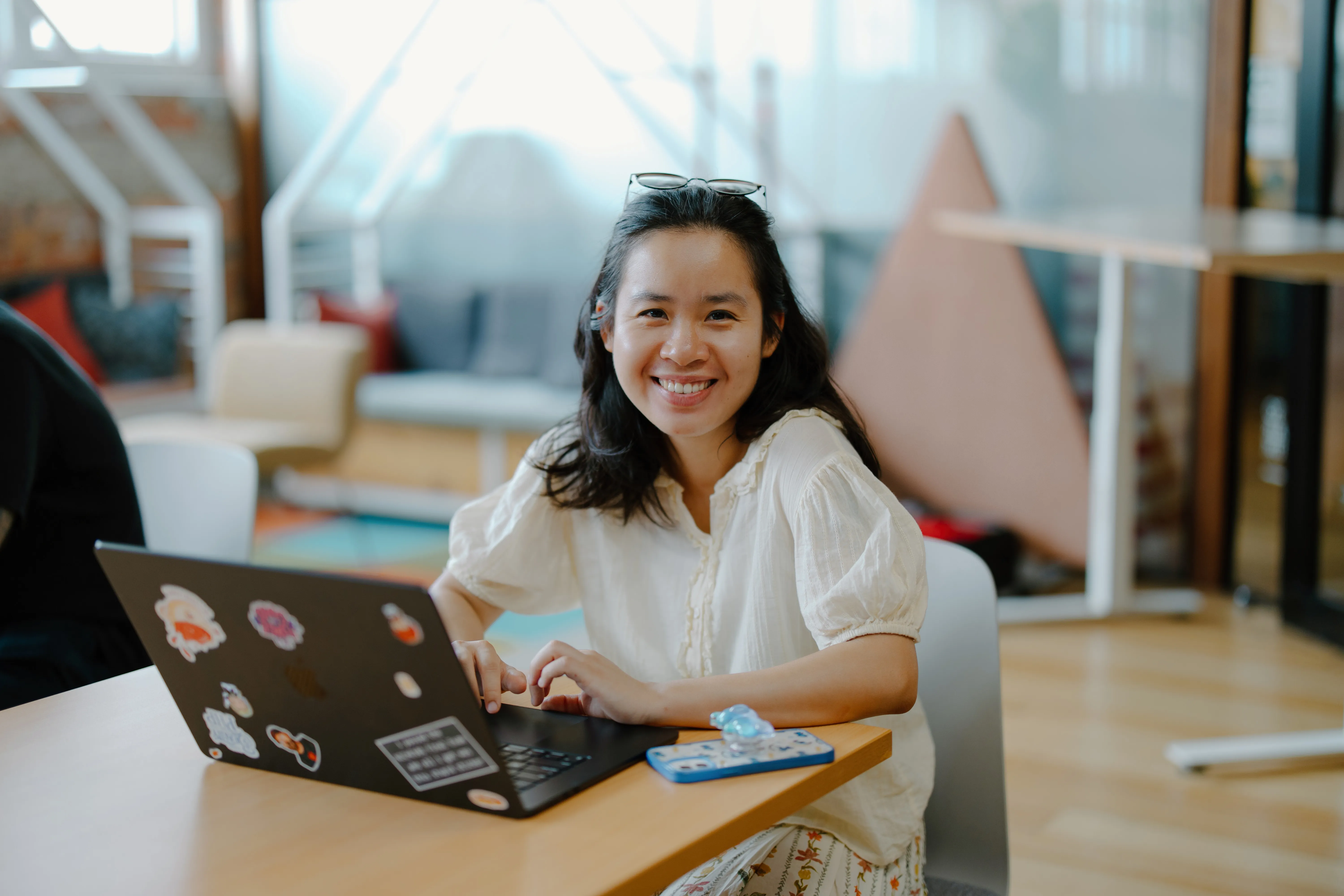 Lucy sits at a laptop, smiling