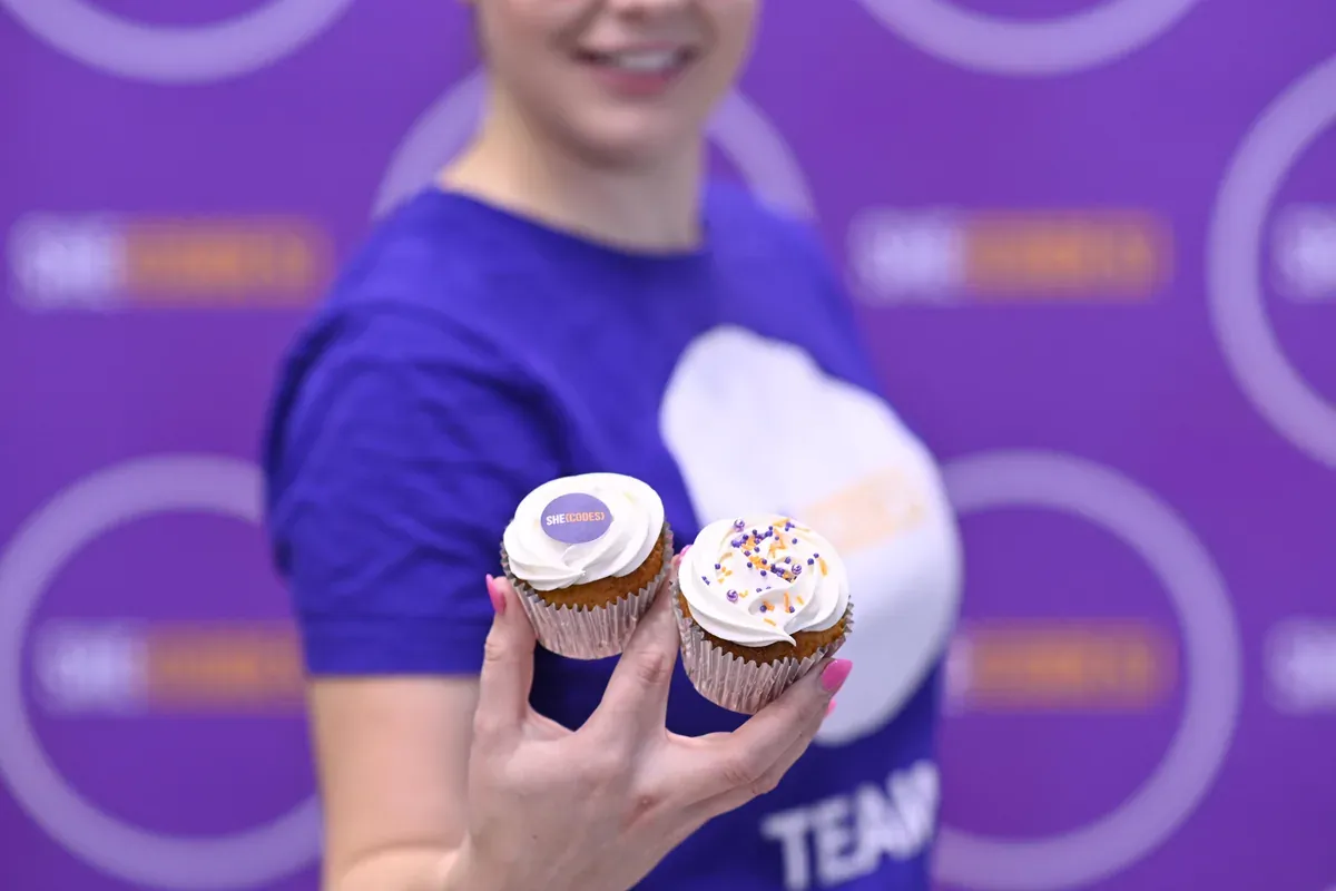She Codes Australia branded cupcakes held up at an event