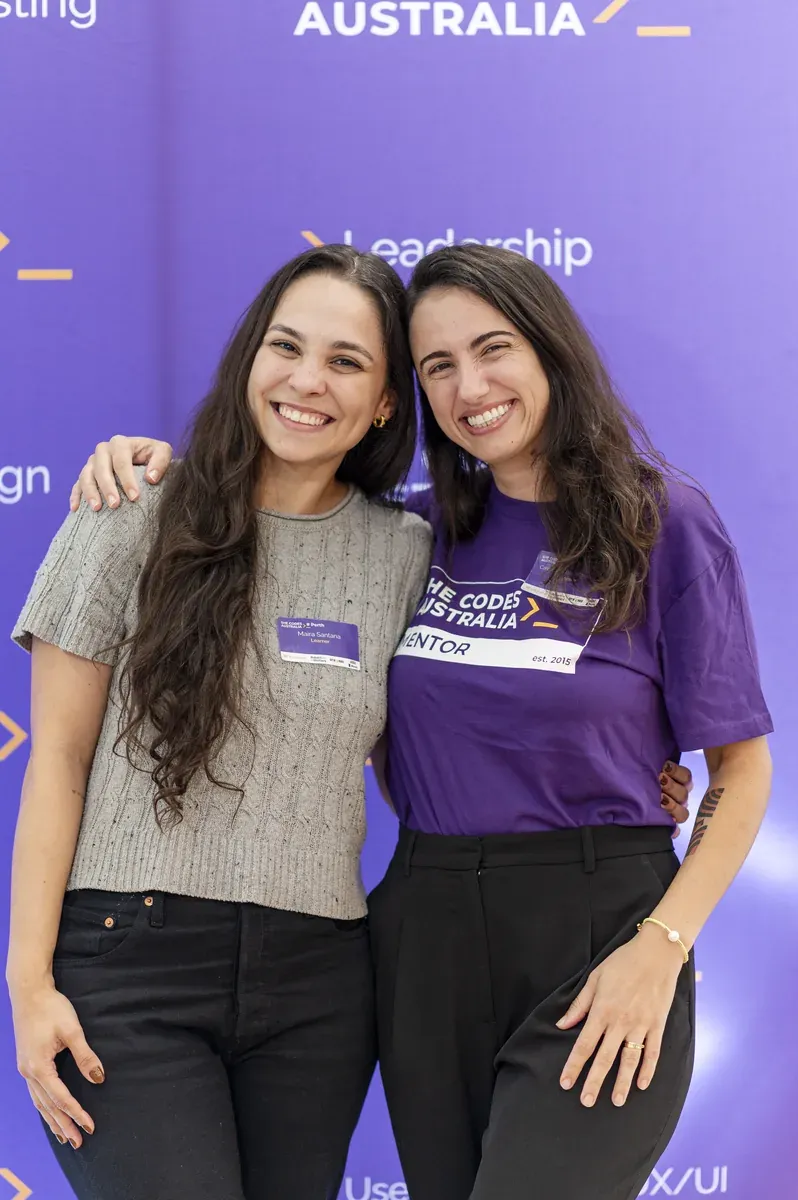 A learner and mentor embracing at a She Codes Australia event