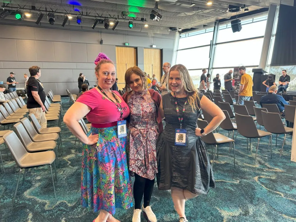 Jo Minney, Nina Karisik, and Kate Kirwin (in bright, patterned dresses) smiling after their presentations at DDD Perth.