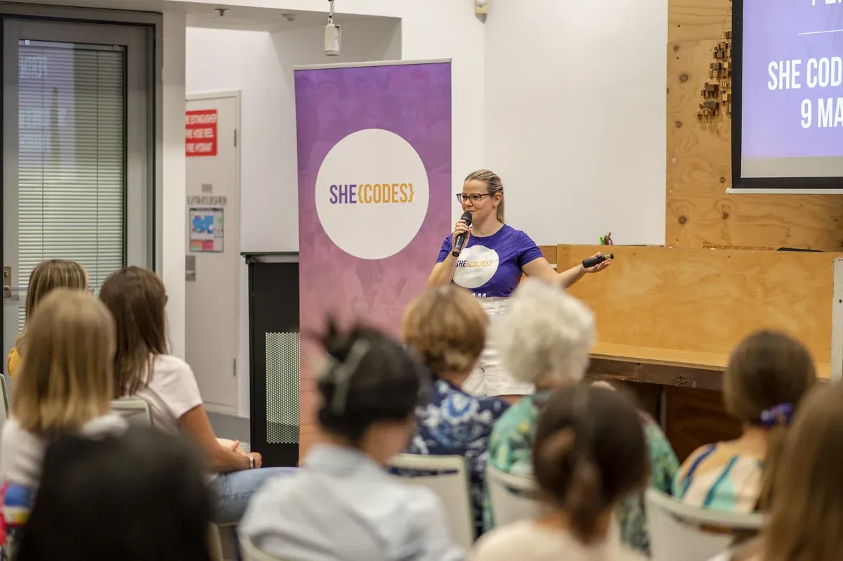 A She Codes Australia facilitator speaking to a workshop audience